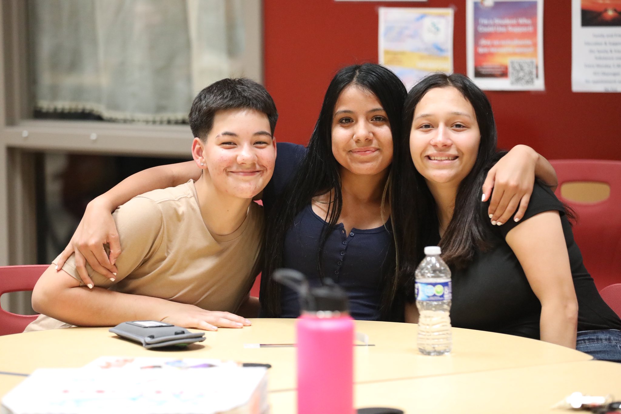 a group pf three students at a table